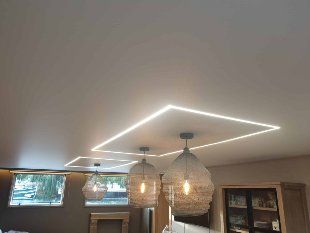 Réalisation d’un plafond tendu blanc satin dans la pièce à vivre d’une péniche.