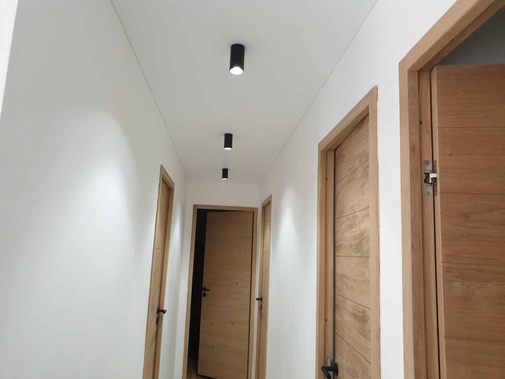 ‌Réalisation d’un plafond blanc mat dans un couloir.