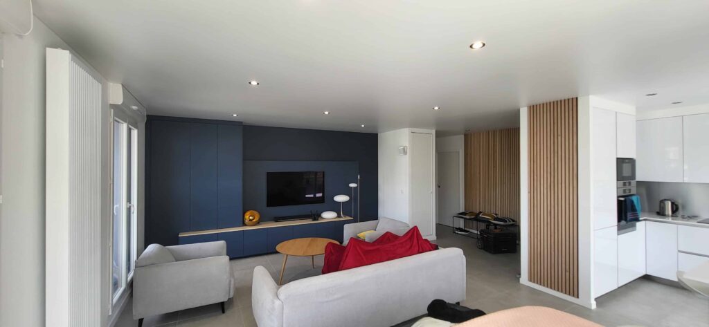 ‌Réalisation d’un plafond tendu blanc satin avec seulement une soudure à peine perceptible dans un grand salon cuisine et entré.